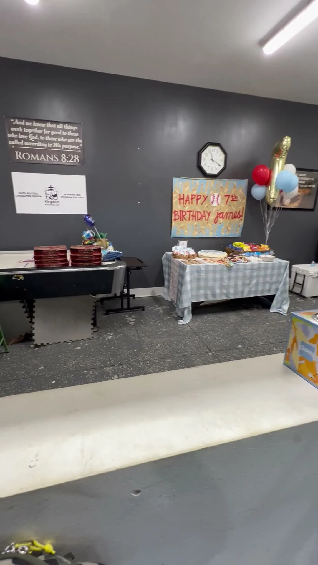 Birthday party room setup with banner, balloons, and food table